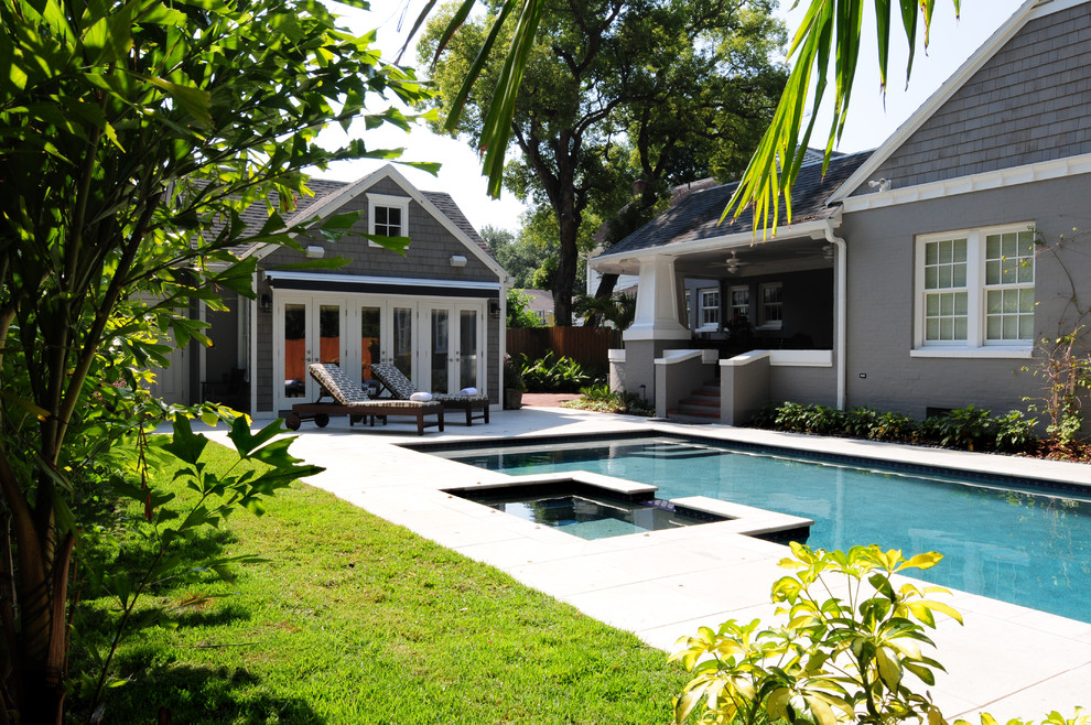 Photo of a large arts and crafts backyard rectangular lap pool in Tampa with a hot tub and concrete slab.