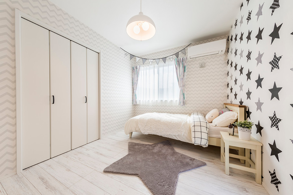 Scandinavian gender-neutral kids' bedroom in Tokyo with multi-coloured walls and light hardwood floors for kids 4-10 years old.