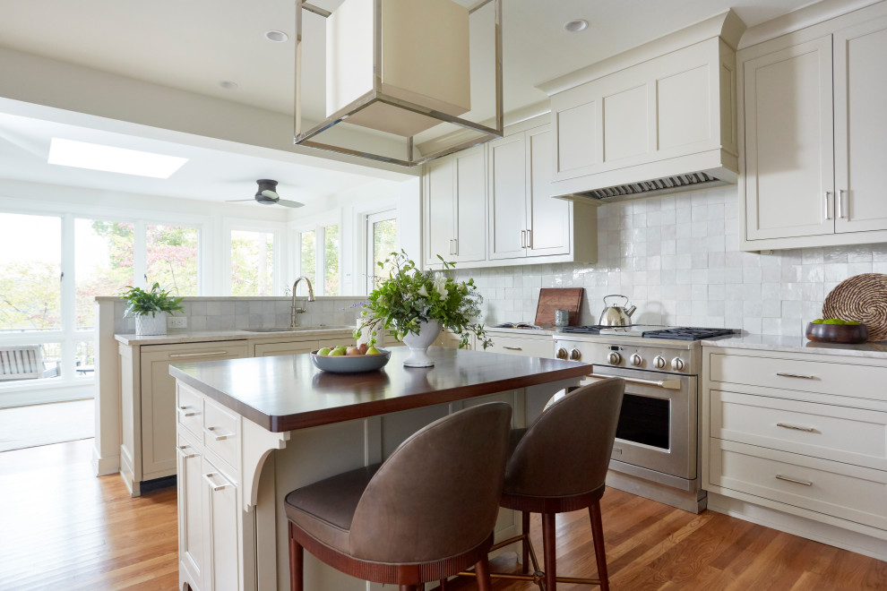 Mid-sized transitional u-shaped separate kitchen with an undermount sink, beaded inset cabinets, beige cabinets, quartzite benchtops, white splashback, terra-cotta splashback, stainless steel appliances, medium hardwood floors, with island, brown floor and beige benchtop.