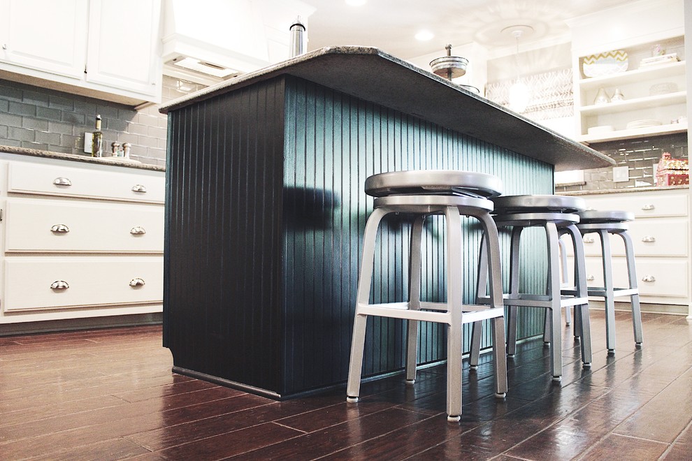 Enclosed kitchen - mid-sized transitional l-shaped dark wood floor and brown floor enclosed kitchen idea with raised-panel cabinets, white cabinets, granite countertops, gray backsplash, glass tile backsplash, an island, stainless steel appliances and an undermount sink