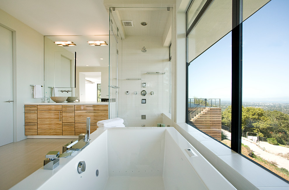 Inspiration for a large contemporary master bathroom in San Francisco with a vessel sink, flat-panel cabinets, granite benchtops, a freestanding tub, a corner shower, white tile, stone tile, white walls, ceramic floors and light wood cabinets.