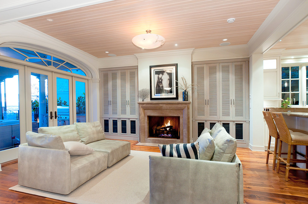 Contemporary open concept living room in Vancouver with white walls, a standard fireplace and a concealed tv.