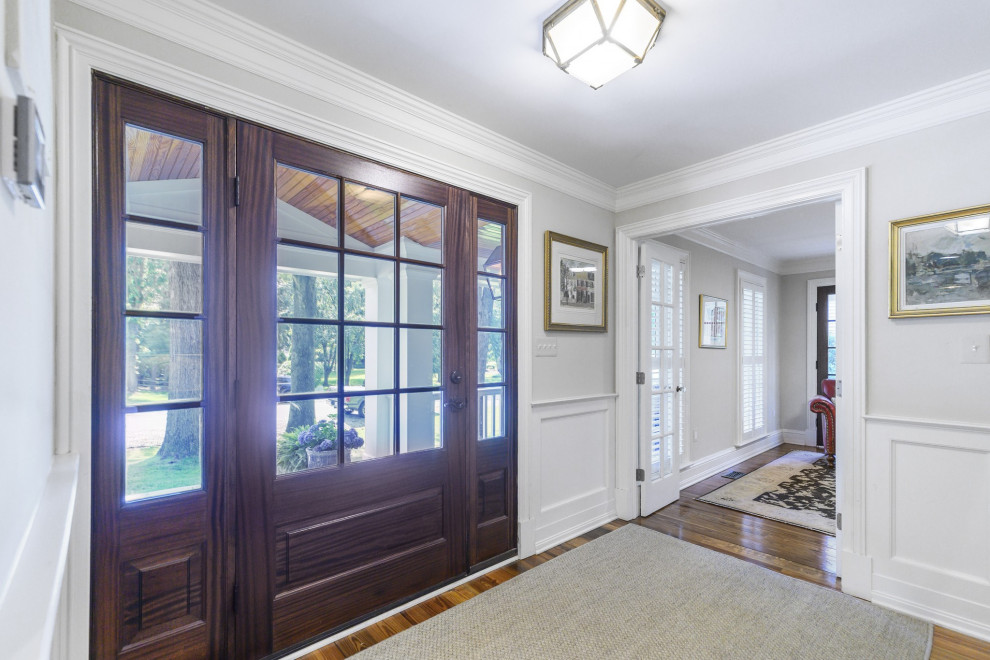 Entryway - mid-sized traditional dark wood floor and red floor entryway idea in DC Metro with white walls and a dark wood front door