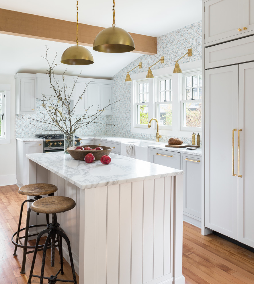 Design ideas for a transitional l-shaped kitchen in Seattle with a farmhouse sink, shaker cabinets, grey cabinets, blue splashback, black appliances, medium hardwood floors and with island.