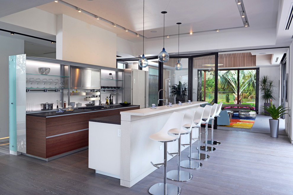 Inspiration for a contemporary galley open plan kitchen in Miami with flat-panel cabinets and dark wood cabinets.