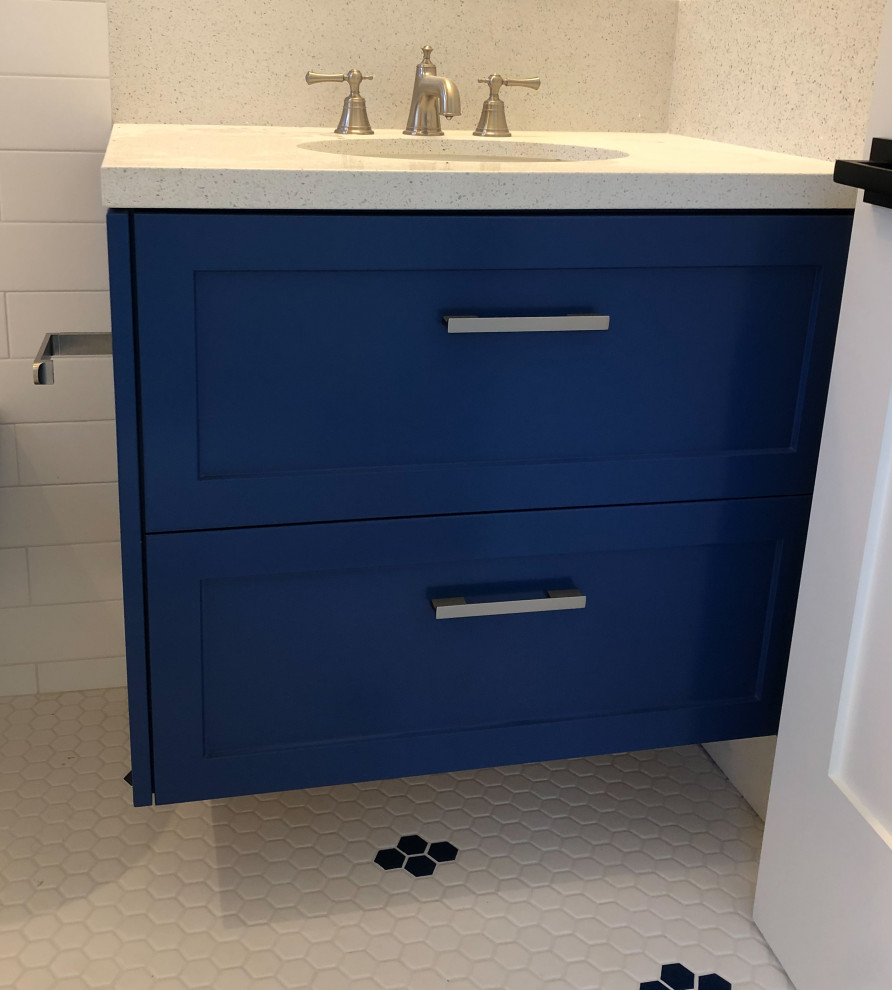 Cette image montre une petite salle de bain principale marine avec un placard à porte shaker, des portes de placard bleues, WC suspendus, un carrelage blanc, des carreaux de céramique, un mur blanc, un sol en carrelage de céramique, un lavabo encastré, un plan de toilette en quartz modifié, un sol bleu, un plan de toilette blanc, une niche, meuble simple vasque et meuble-lavabo suspendu.