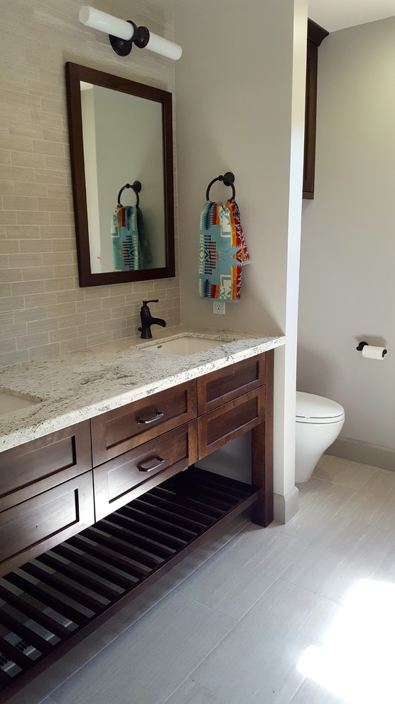 Large mountain style master gray tile and ceramic tile ceramic tile home design photo with shaker cabinets, medium tone wood cabinets, a one-piece toilet, gray walls, a drop-in sink and granite countertops