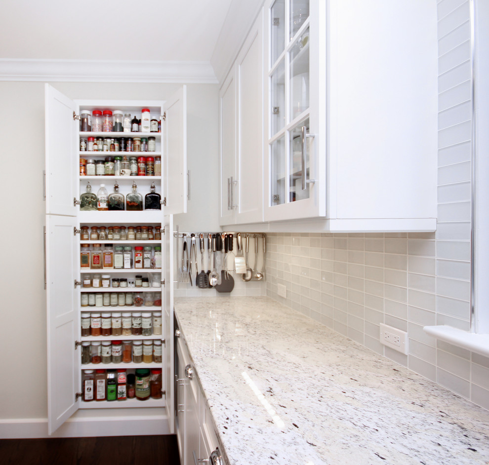 Inspiration for a mid-sized transitional single-wall kitchen pantry in New York with with island, a drop-in sink, raised-panel cabinets, white cabinets, soapstone benchtops, white splashback, ceramic splashback, stainless steel appliances, medium hardwood floors, brown floor, white benchtop and vaulted.