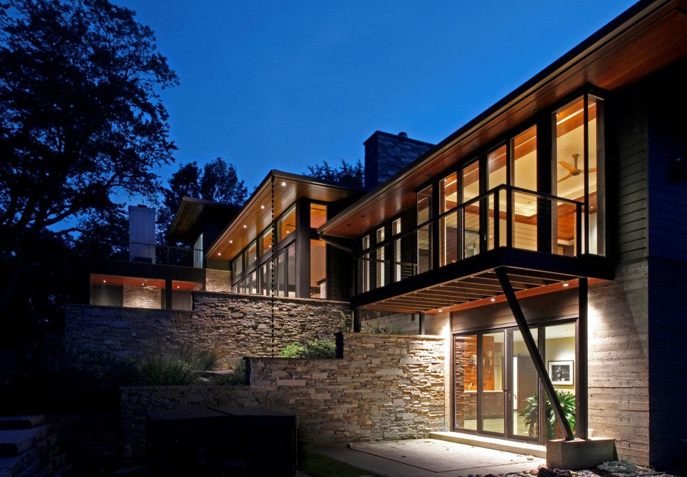 Свежая идея для дизайна: большой, трехэтажный, серый частный загородный дом в стиле модернизм с облицовкой из камня, вальмовой крышей, серой крышей и отделкой планкеном - отличное фото интерьера