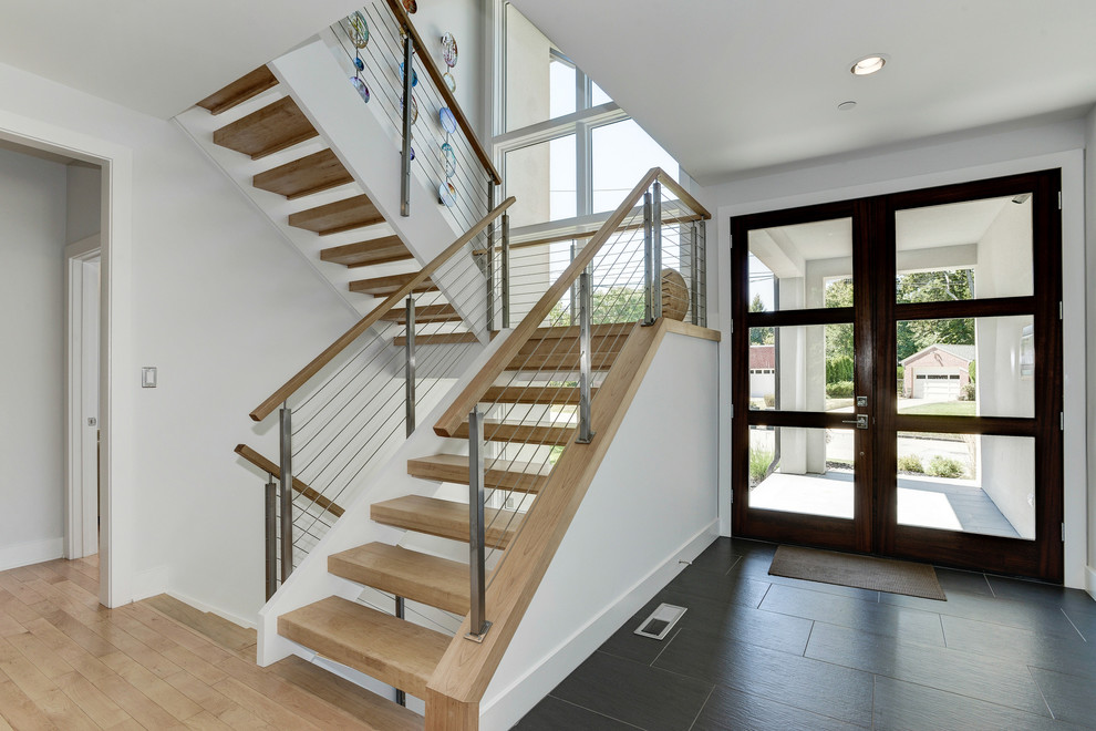Photo of a mid-sized contemporary foyer in DC Metro with white walls, ceramic floors, a double front door and a glass front door.
