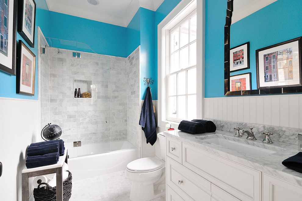 Photo of a mid-sized eclectic master bathroom in Other with recessed-panel cabinets, white cabinets, a shower/bathtub combo, blue walls, an undermount sink and a hinged shower door.