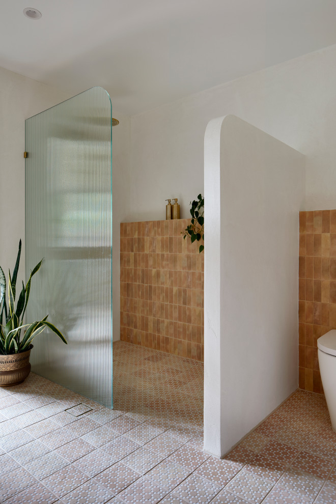 Example of a mid-sized minimalist master pink tile and porcelain tile porcelain tile, pink floor and single-sink open shower design in Melbourne with furniture-like cabinets, a two-piece toilet, white walls, white countertops, a floating vanity and medium tone wood cabinets