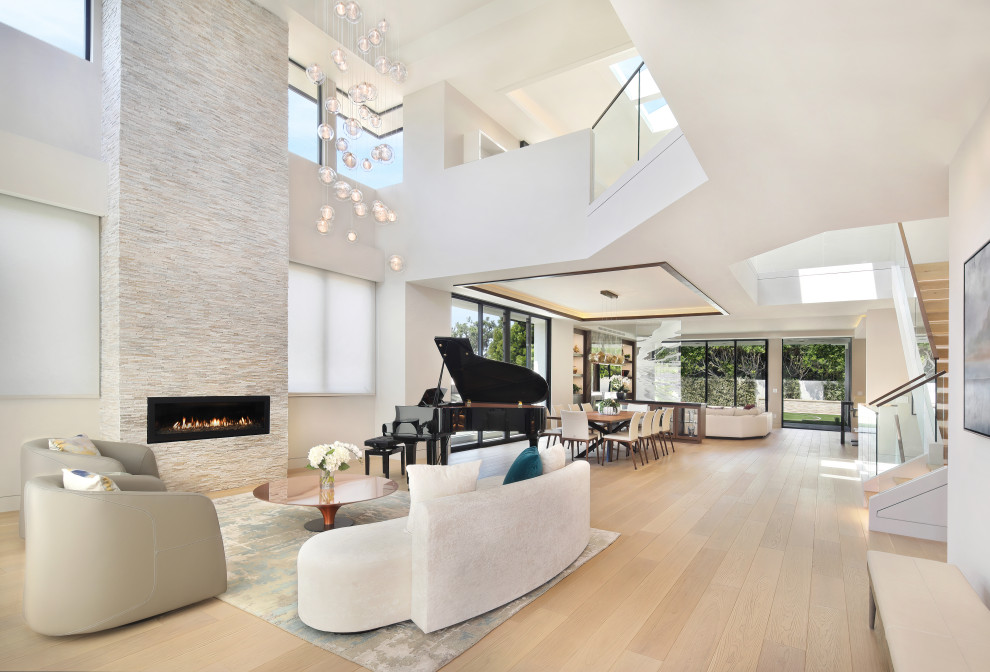 Inspiration for an expansive modern open concept living room in Los Angeles with beige floor, light hardwood floors, a stone fireplace surround, grey walls and recessed.