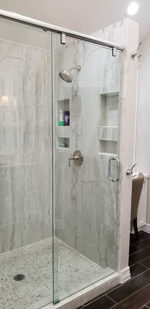 Mid-sized modern master bathroom in Houston with raised-panel cabinets, white cabinets, an open shower, a one-piece toilet, white tile, porcelain tile, white walls, porcelain floors, an undermount sink, engineered quartz benchtops, brown floor, a hinged shower door and white benchtops.