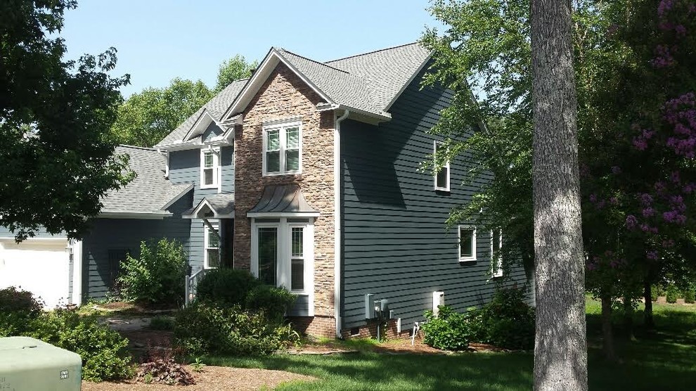 Inspiration for a large timeless blue two-story mixed siding exterior home remodel in Raleigh with a hip roof