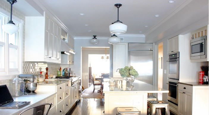 Example of a mid-sized transitional dark wood floor and black floor enclosed kitchen design in Chicago with shaker cabinets, white cabinets, quartz countertops, beige backsplash, ceramic backsplash, stainless steel appliances and an island