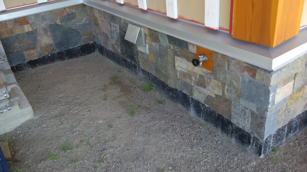 Example of a mountain style stone house exterior design