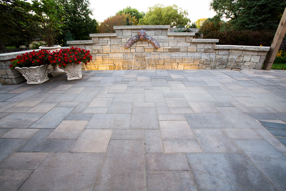 Inspiration for a transitional backyard stone water fountain landscape in Omaha.