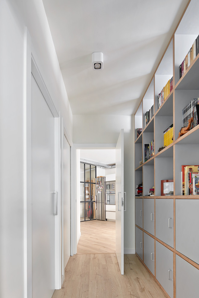 Mid-sized contemporary hallway in Barcelona with white walls and light hardwood floors.