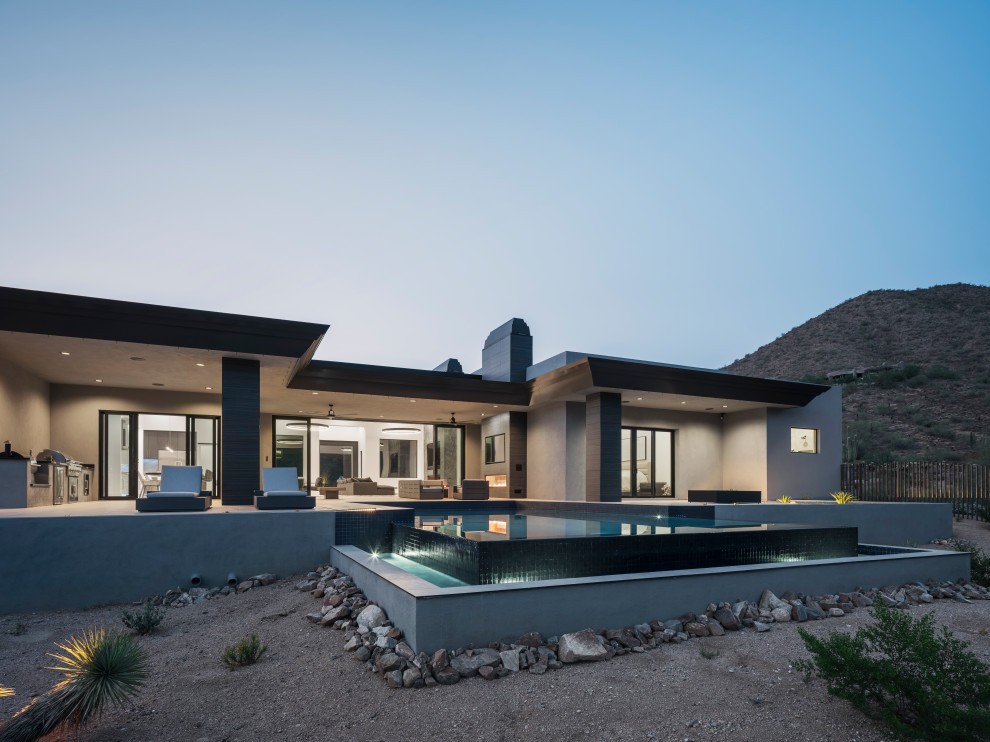 Inspiration for a large modern one-storey stucco grey house exterior in Phoenix with a flat roof, a mixed roof and a black roof.