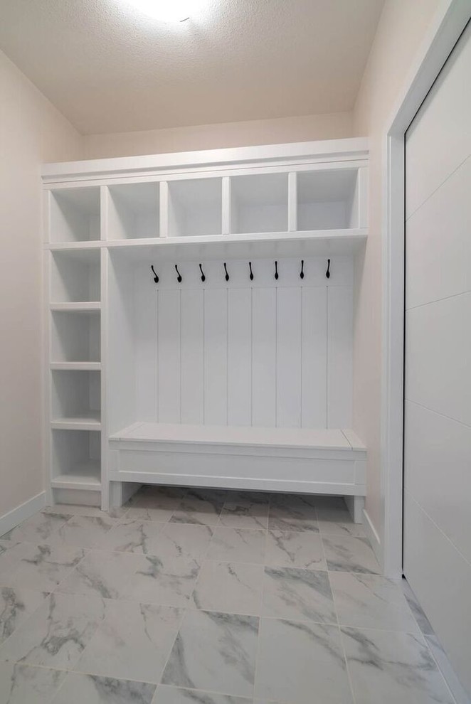 This is an example of a mid-sized arts and crafts mudroom in Other with beige walls, marble floors, a single front door, a white front door and grey floor.