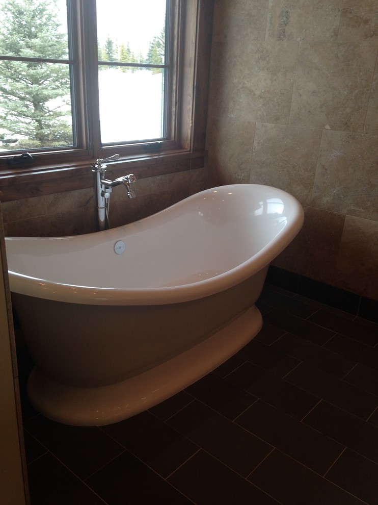 Mid-sized transitional master stone tile slate floor freestanding bathtub photo with brown walls