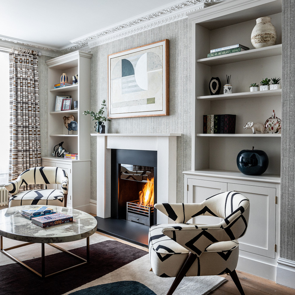 Mittelgroßes, Repräsentatives Klassisches Wohnzimmer mit grauer Wandfarbe, hellem Holzboden, Kamin, Kaminumrandung aus Holz, braunem Boden und Tapetenwänden in London