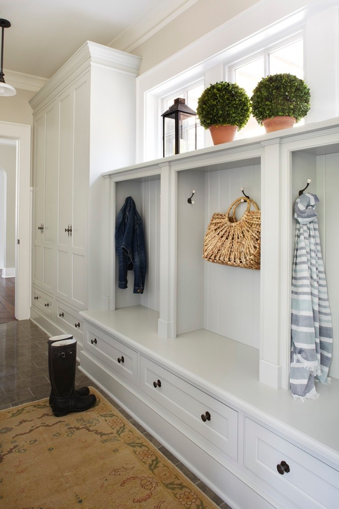 Photo of a traditional mudroom in Chicago with white walls and limestone floors.