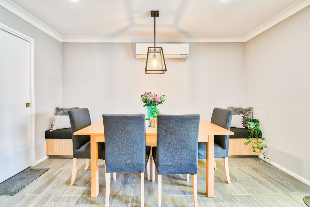 Transitional separate dining room in Brisbane with grey walls and grey floor.