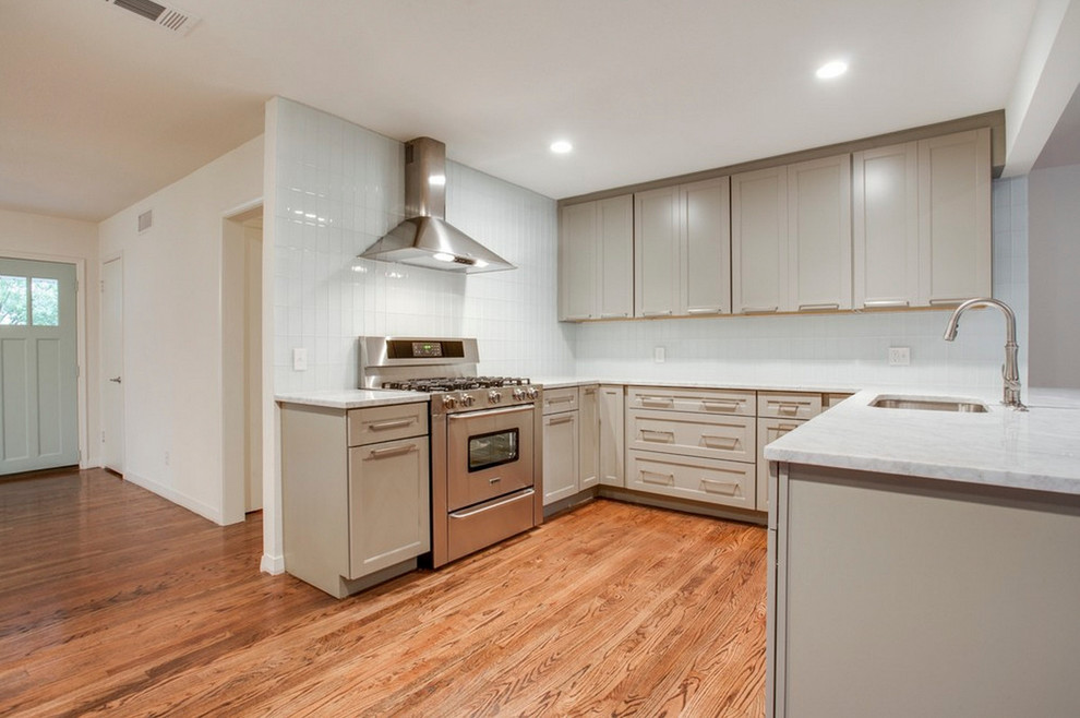 Kitchen - small transitional u-shaped medium tone wood floor kitchen idea with a single-bowl sink, recessed-panel cabinets, gray cabinets, marble countertops, white backsplash, glass tile backsplash and stainless steel appliances