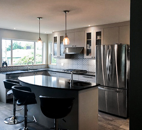 Large eclectic u-shaped laminate floor and brown floor eat-in kitchen photo with an undermount sink, glass-front cabinets, gray cabinets, quartz countertops, multicolored backsplash, ceramic backsplash, stainless steel appliances, an island and black countertops