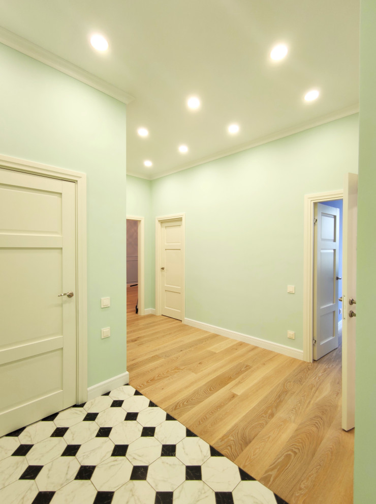 Idées déco pour un couloir de taille moyenne avec un mur vert, un sol en bois brun, un sol multicolore et du papier peint.