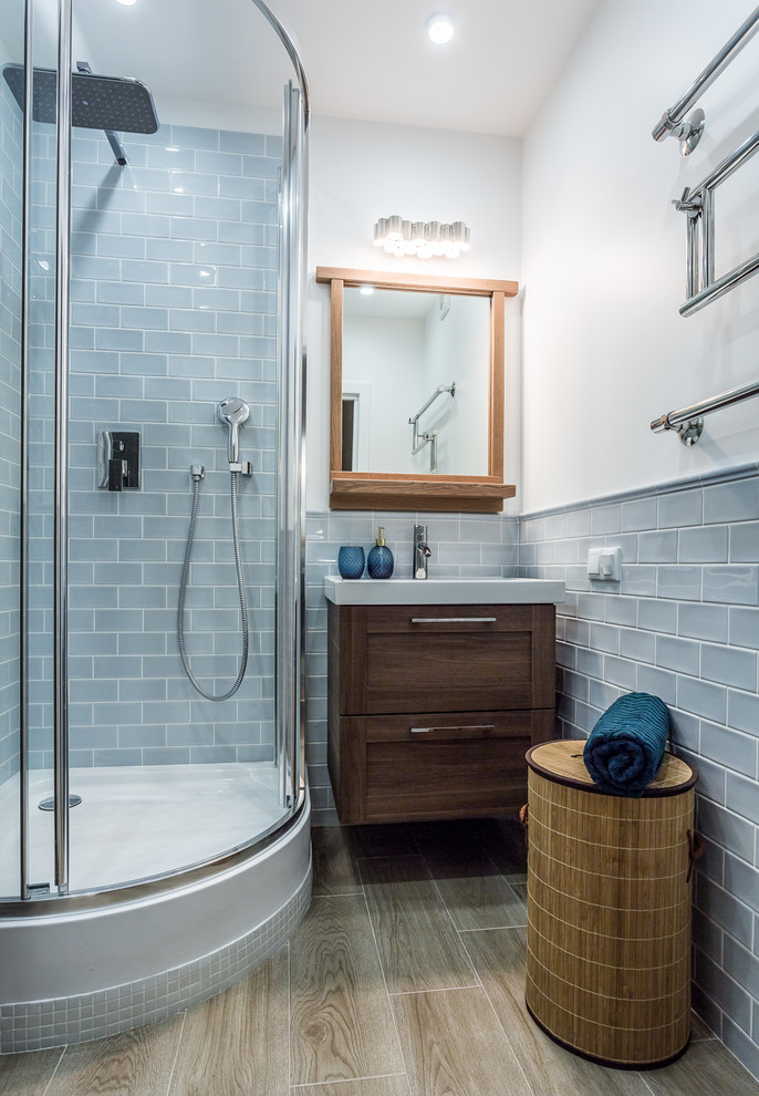 На фото: ванная комната с бежевыми фасадами, угловым душем, унитазом-моноблоком, синей плиткой, керамической плиткой, синими стенами, полом из керамической плитки и консольной раковиной с