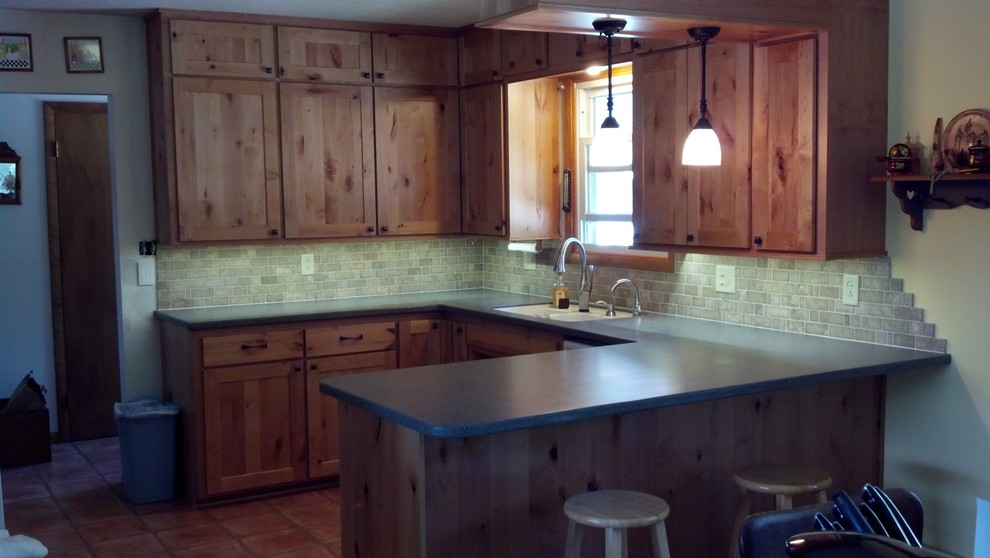 Inspiration for a small rustic u-shaped terra-cotta tile eat-in kitchen remodel with a double-bowl sink, light wood cabinets, gray backsplash, cement tile backsplash and no island
