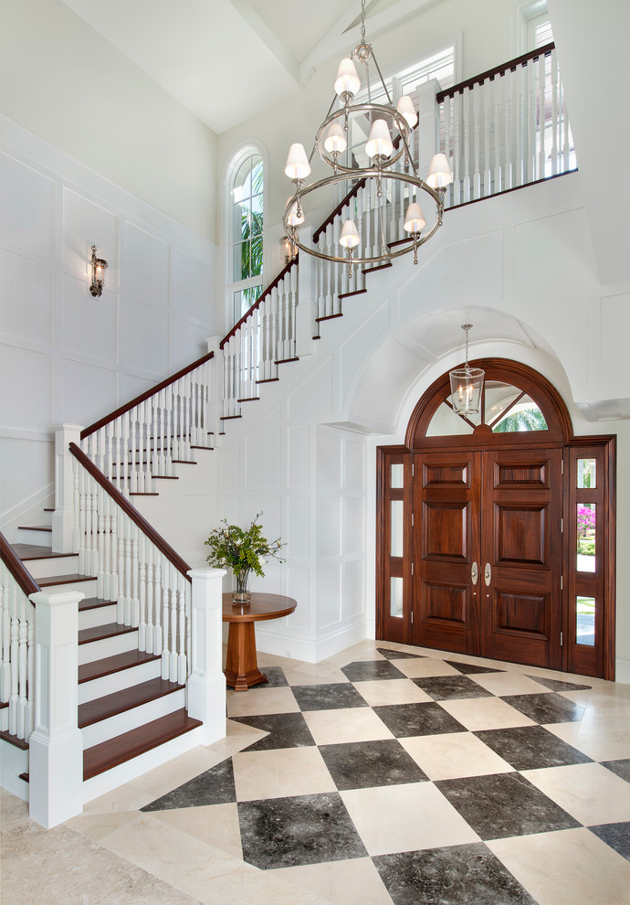 This is an example of a large tropical foyer in Miami with white walls, marble floors, a double front door, a dark wood front door and multi-coloured floor.