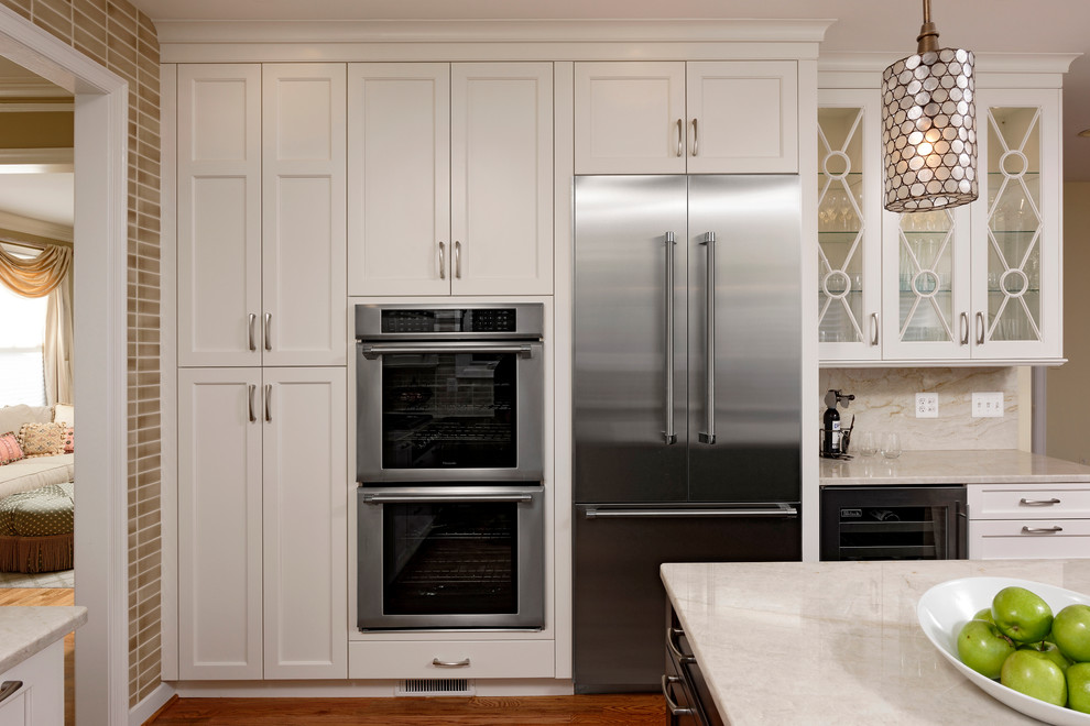 Example of a large transitional l-shaped light wood floor and brown floor eat-in kitchen design in DC Metro with an undermount sink, recessed-panel cabinets, white cabinets, granite countertops, gray backsplash, mosaic tile backsplash, stainless steel appliances and an island