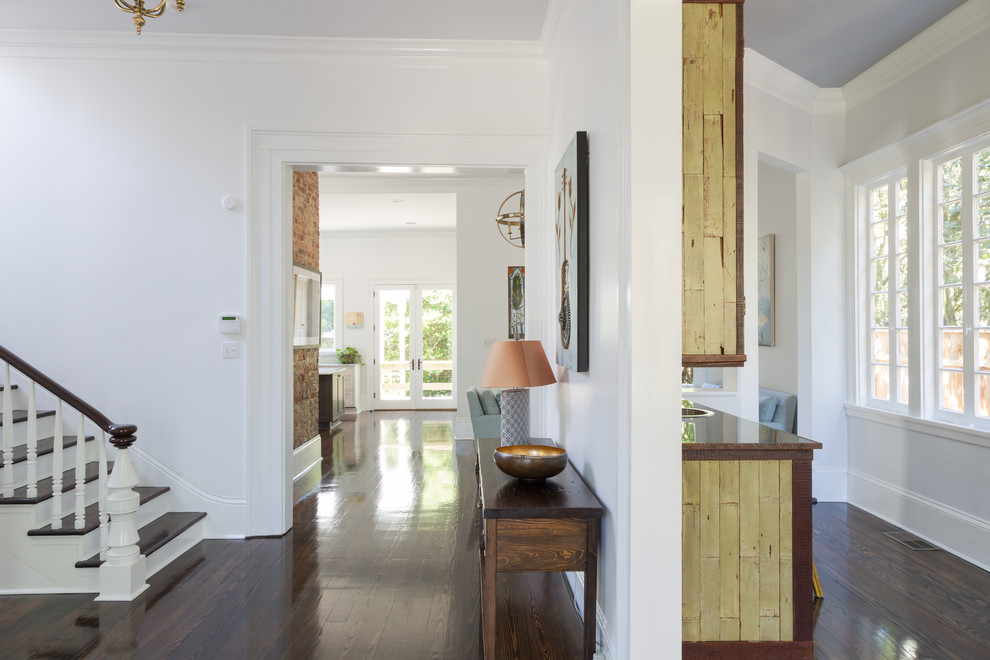 This is an example of a mid-sized eclectic foyer in New Orleans with white walls, medium hardwood floors, a single front door and a white front door.