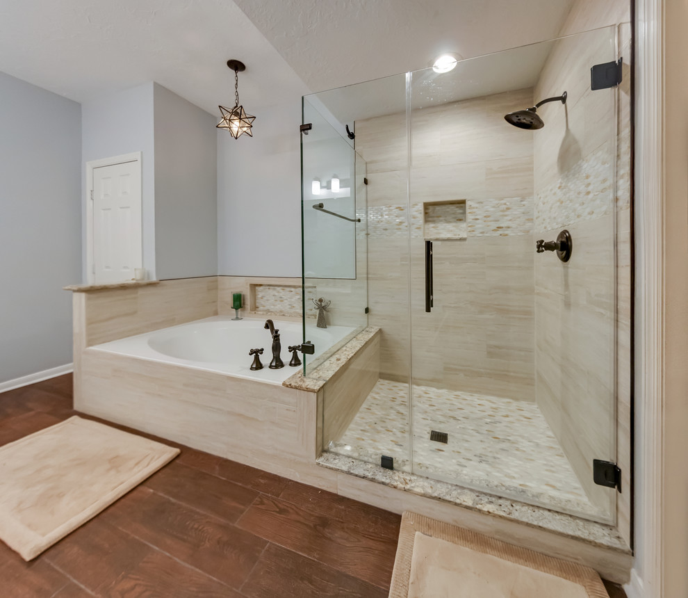 Design ideas for a mid-sized beach style master bathroom in Houston with a corner tub, a corner shower, beige tile, porcelain tile, grey walls, dark hardwood floors, brown floor and a hinged shower door.