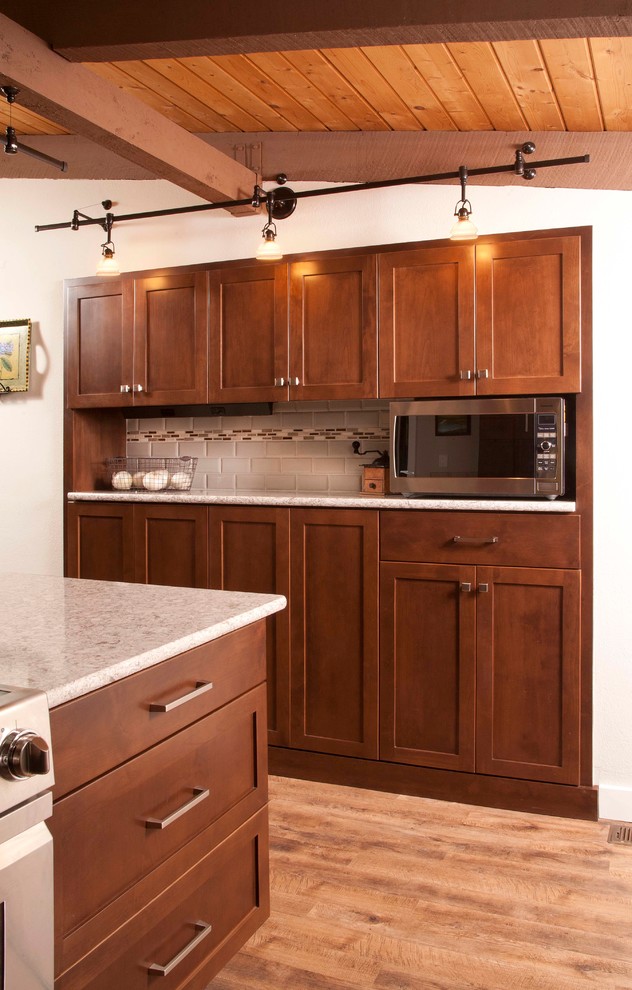 Example of a mid-sized transitional dark wood floor kitchen design in Seattle with an undermount sink, shaker cabinets, dark wood cabinets, beige backsplash, subway tile backsplash, stainless steel appliances and a peninsula