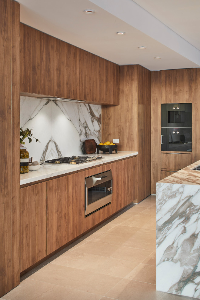 Mid-sized contemporary l-shaped kitchen in Sydney with flat-panel cabinets, medium wood cabinets, grey splashback, panelled appliances, porcelain floors, with island, beige floor and grey benchtop.