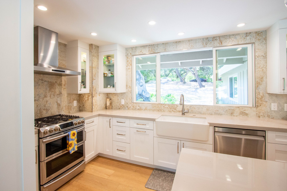 Inspiration for a transitional l-shaped light wood floor and brown floor eat-in kitchen remodel with a farmhouse sink, shaker cabinets, white cabinets, quartz countertops, porcelain backsplash, stainless steel appliances and an island
