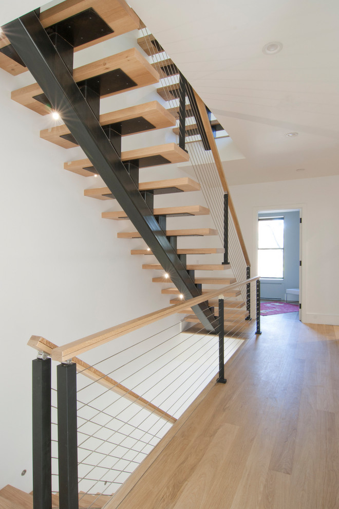 Example of a mid-sized minimalist wooden floating open and cable railing staircase design in New York