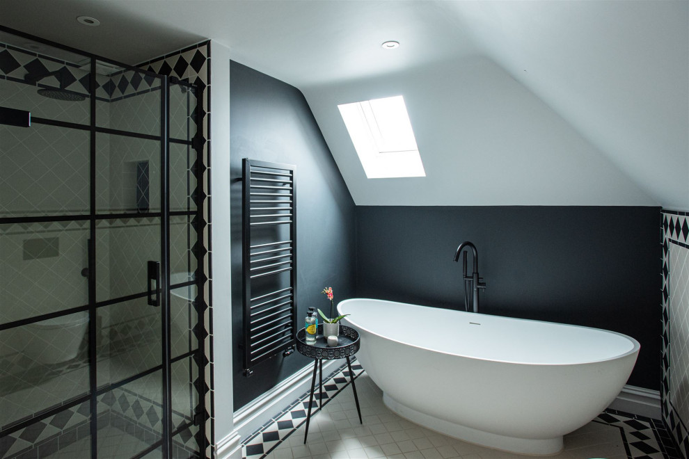 Aménagement d'une salle de bain classique avec une baignoire indépendante, un carrelage noir et blanc, un mur noir et un sol multicolore.
