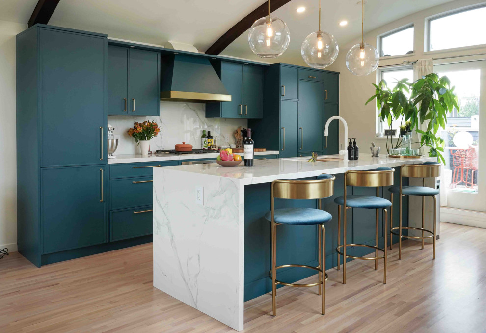 Design ideas for a mid-sized contemporary galley eat-in kitchen in Vancouver with a double-bowl sink, flat-panel cabinets, turquoise cabinets, marble benchtops, white splashback, marble splashback, panelled appliances, light hardwood floors, with island, beige floor, white benchtop and wood.