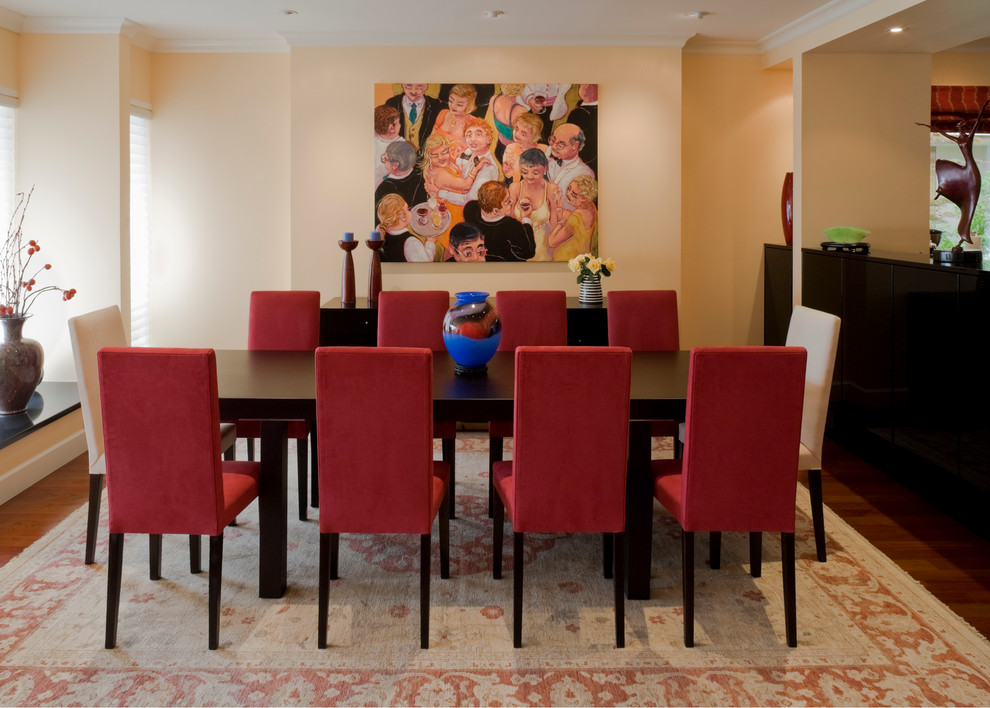This is an example of a large transitional dining room in Vancouver with yellow walls and medium hardwood floors.