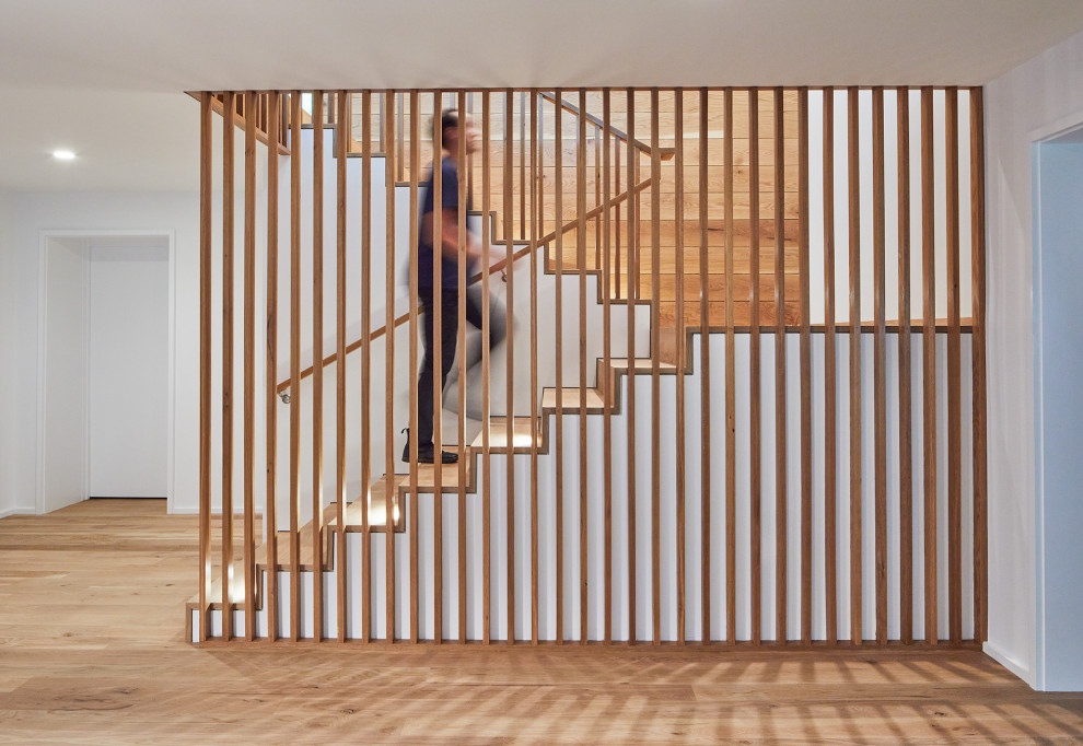 ワシントンD.C.にある高級な中くらいなミッドセンチュリースタイルのおしゃれな折り返し階段 (木の蹴込み板、木材の手すり、板張り壁) の写真