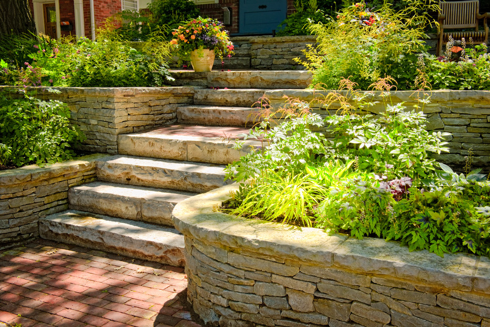 Inspiration for a mid-sized transitional partial sun front yard stone retaining wall landscape in Calgary.