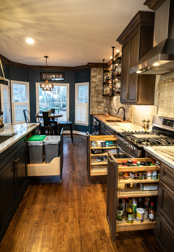 Photo of a mid-sized modern l-shaped kitchen pantry in Atlanta with a single-bowl sink, flat-panel cabinets, dark wood cabinets, marble benchtops, multi-coloured splashback, subway tile splashback, stainless steel appliances, dark hardwood floors, with island, brown floor and blue benchtop.