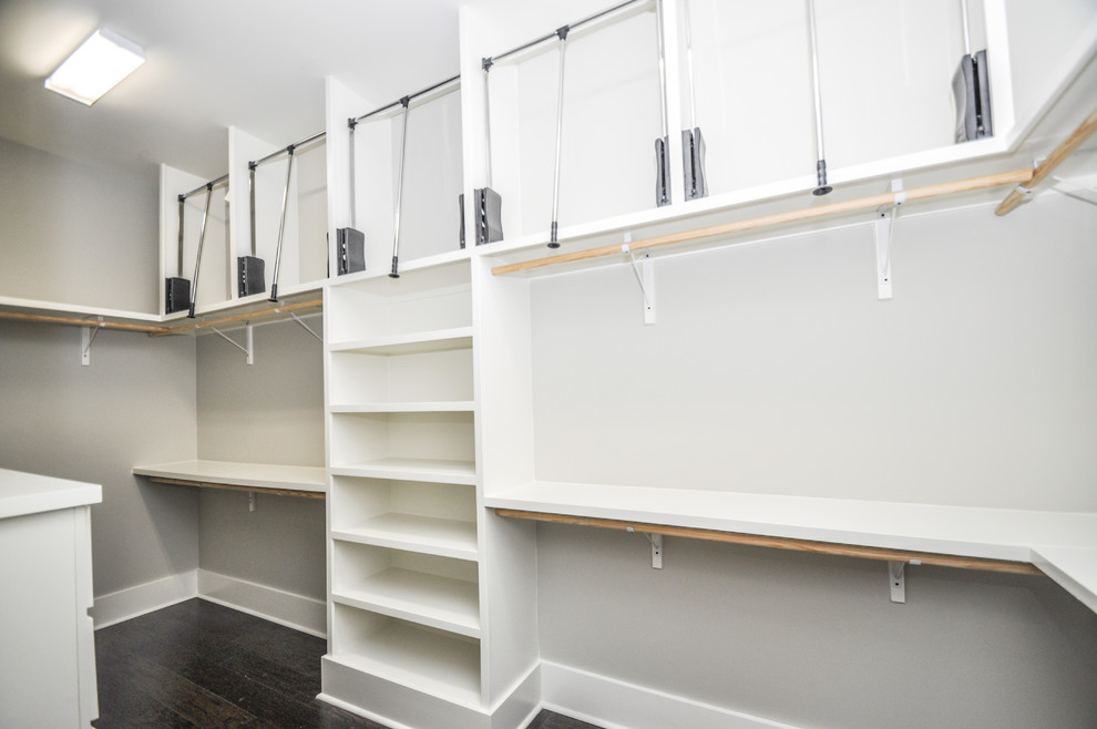 Inspiration for a large arts and crafts gender-neutral walk-in wardrobe in New Orleans with raised-panel cabinets, white cabinets and dark hardwood floors.