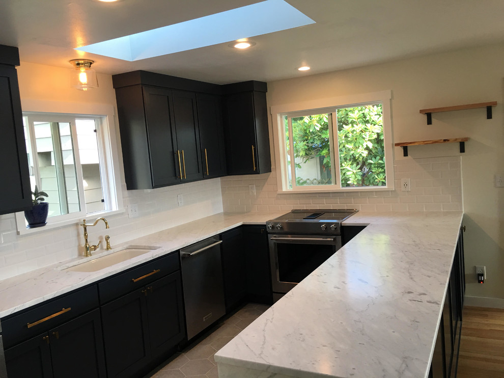 Enclosed kitchen - mid-sized transitional l-shaped enclosed kitchen idea in Seattle with shaker cabinets, black cabinets, white backsplash, subway tile backsplash, stainless steel appliances and a peninsula